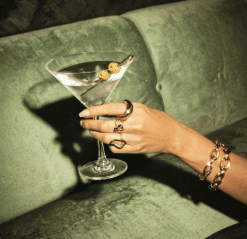 Hand holding a glass on green velvet
